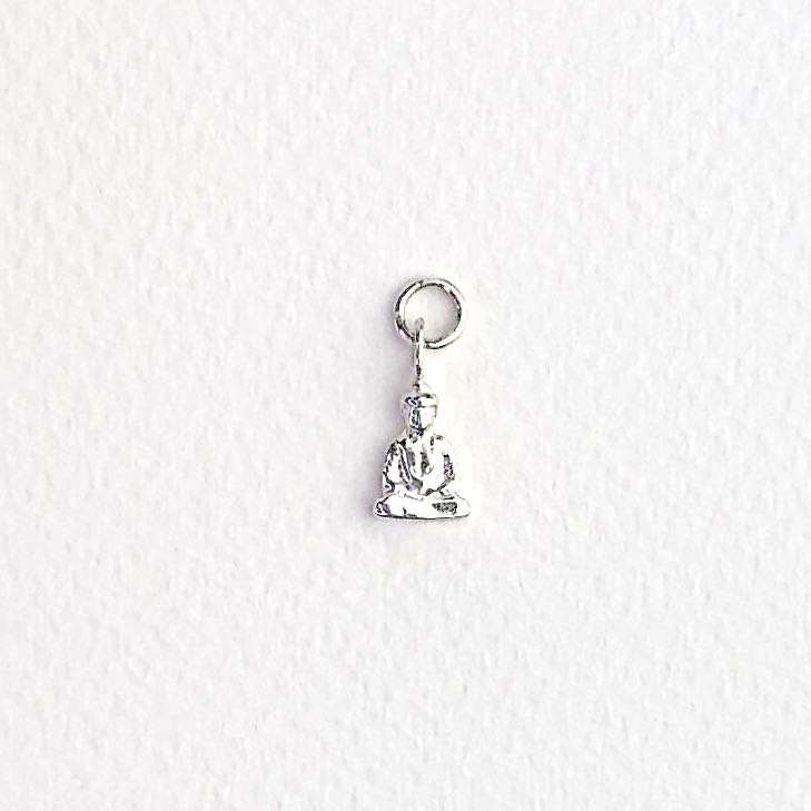 Charm srebrny Budda na jasnym tle.