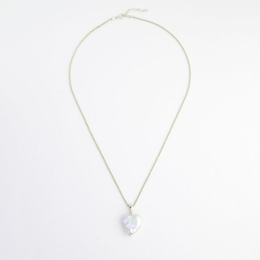 Srebrny naszyjnik z zawieszką z perły naturalnej w kształcie serca.